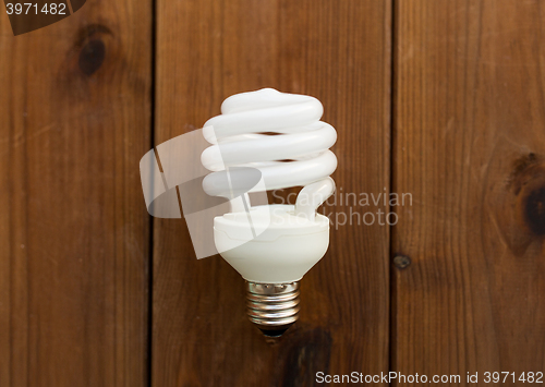 Image of close up of energy saving lighting bulb on wood