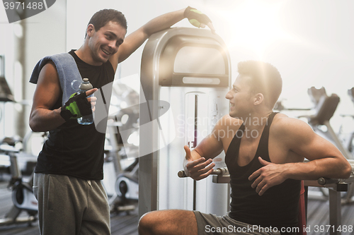 Image of smiling men exercising on gym machine