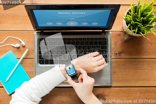 Image of close up of woman with smart watch and laptop