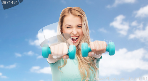 Image of smiling beautiful young sporty woman with dumbbell