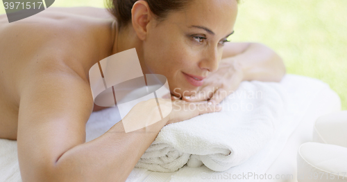 Image of Close up of woman with brown hair relaxes on table