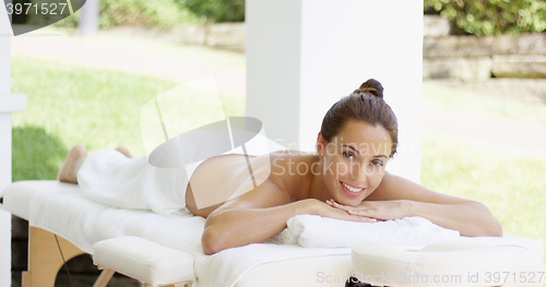 Image of Tranquil spa customer relaxes on table