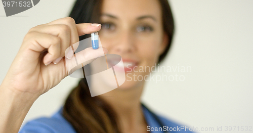 Image of Doctor or nurse holding up a capsule