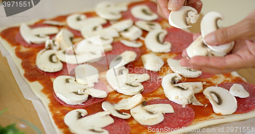 Image of Woman making a delicious pepperoni pizza