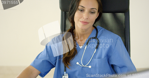 Image of Young female physician places one hand on her face