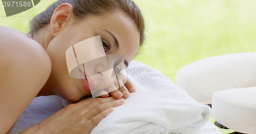 Image of Woman with hair up in a bun rests on folded towel