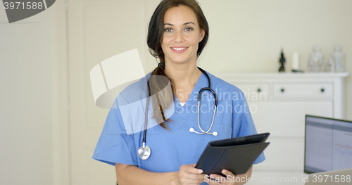 Image of Smiling young female physician smiles at camera