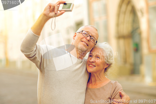 Image of senior couple photographing on city street