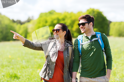 Image of happy couple with backpacks hiking outdoors