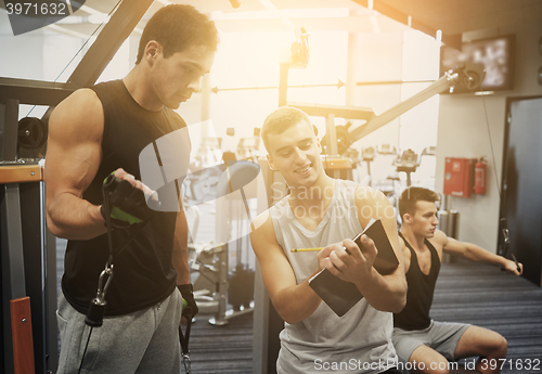 Image of men exercising on gym machine
