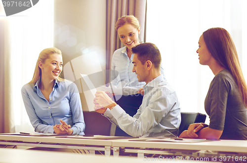 Image of smiling business people with papers in office