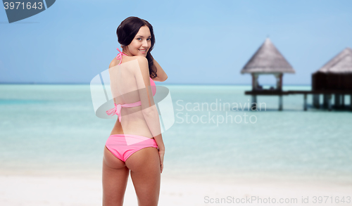 Image of happy young woman in pink bikini swimsuit on beach