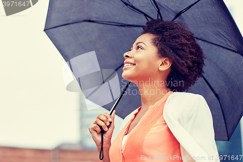 Image of happy african american businesswoman with umbrella