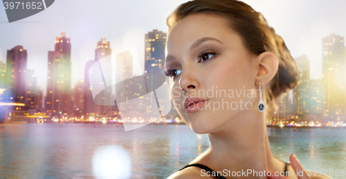 Image of beautiful young asian woman with earring in city