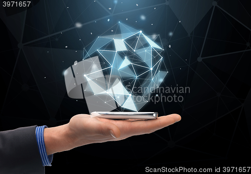 Image of close up of hand with projection and smartphone