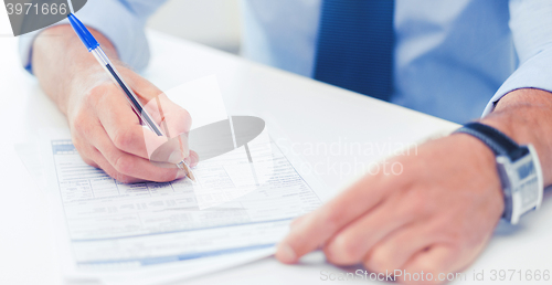 Image of man filling tax form