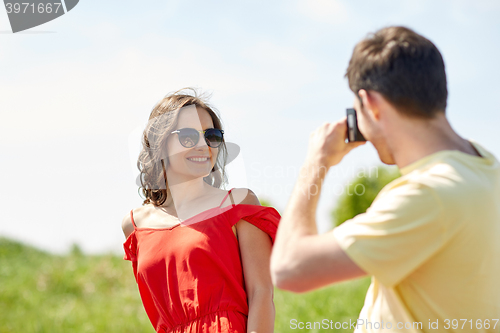 Image of happy couple with camera photographing