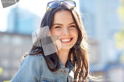 Image of happy smiling young woman on summer city street