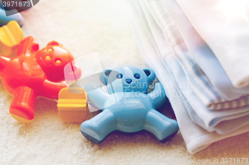 Image of close up of baby rattle and clothes for newborn