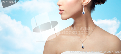 Image of close up of woman with earring and pendant