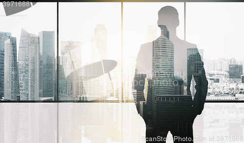 Image of silhouette of business man over office background