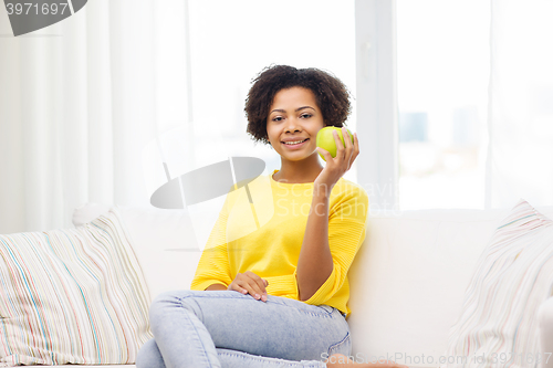 Image of happy african american woman with green apple