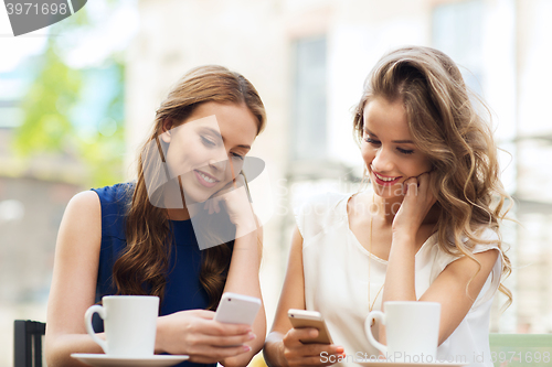 Image of women with smartphones and coffee at outdoor cafe