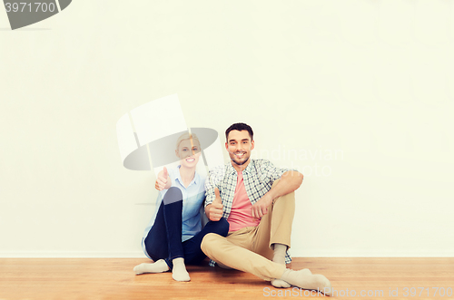 Image of happy couple showing thumbs up at new home