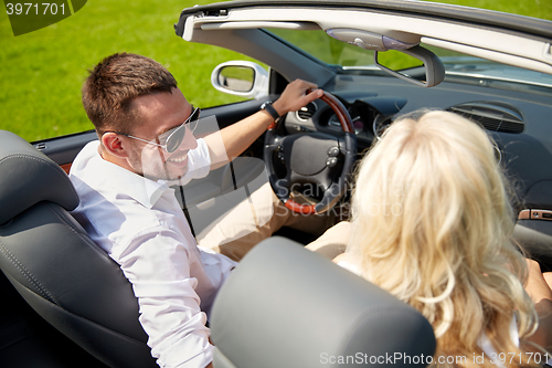 Image of happy man and woman driving in cabriolet car