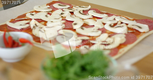 Image of Woman making a delicious pepperoni pizza