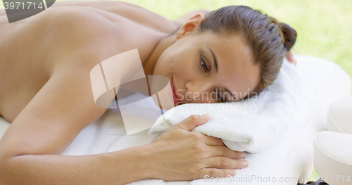 Image of Disrobed woman lays belly down on table