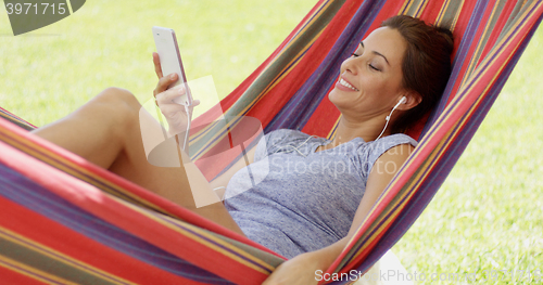 Image of Pretty young woman relaxing in a hammock