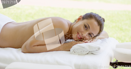 Image of Woman relaxing on spa table  outdoor patio