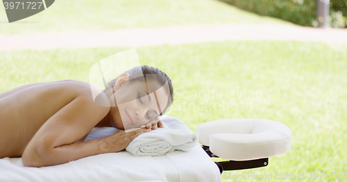 Image of Naked woman on spa table closes her eyes