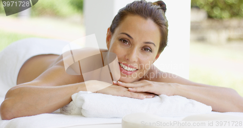 Image of Woman with chin on folded towel smiles