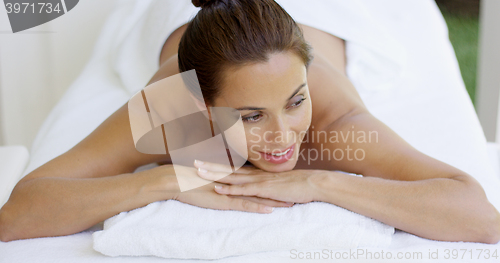 Image of Woman smiles and relaxes on massage table