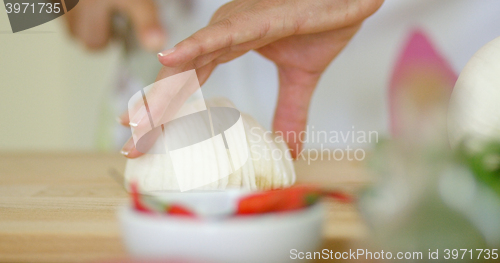 Image of Close up on hands Cutting fresh onion