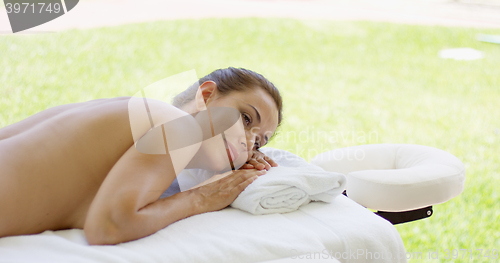 Image of Adorable middle aged woman laying on massage bed