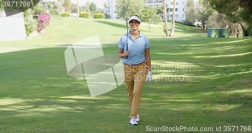Image of Smiling friendly woman golfer walking on a course