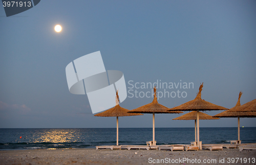 Image of Parasol on a beach and moon