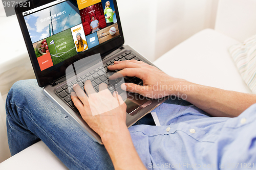 Image of close up of man typing on laptop computer at home