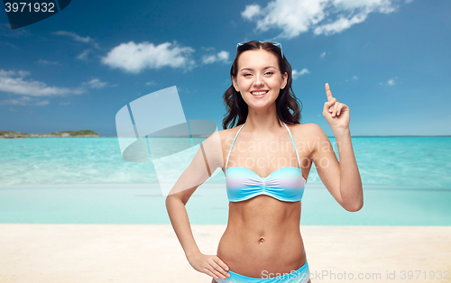 Image of happy woman in bikini swimsuit pointing finger up