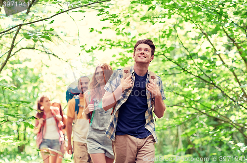 Image of group of smiling friends with backpacks hiking