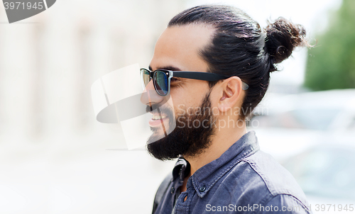 Image of happy smiling man with beard on city street