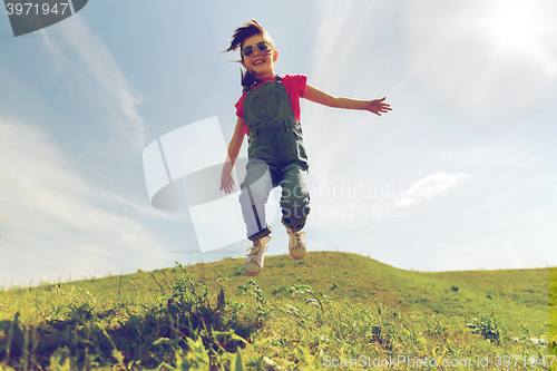 Image of happy little girl jumping high outdoors