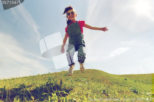 Image of happy little girl jumping high outdoors