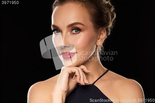 Image of beautiful woman in black over dark background