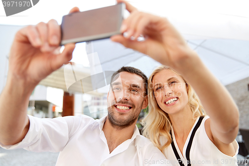 Image of couple taking selfie with smatphone at restaurant