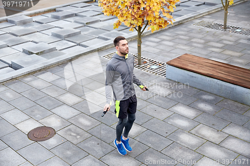 Image of man exercising with jump-rope outdoors