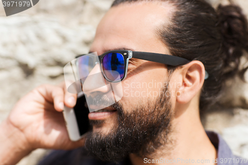 Image of man with smartphone calling on city street